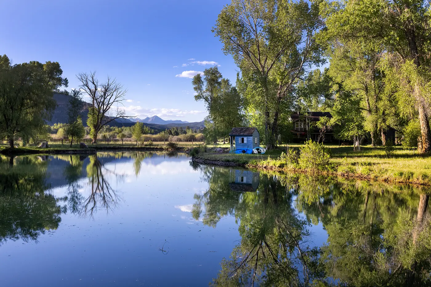 A pond reflecting the mountains on a Durango-area property